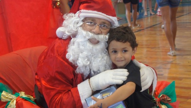 Papai Noel chega de helicóptero e entrega brinquedos às crianças